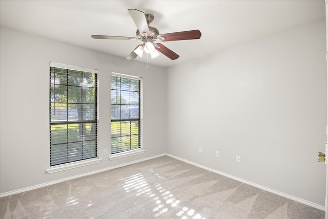 carpeted spare room with ceiling fan