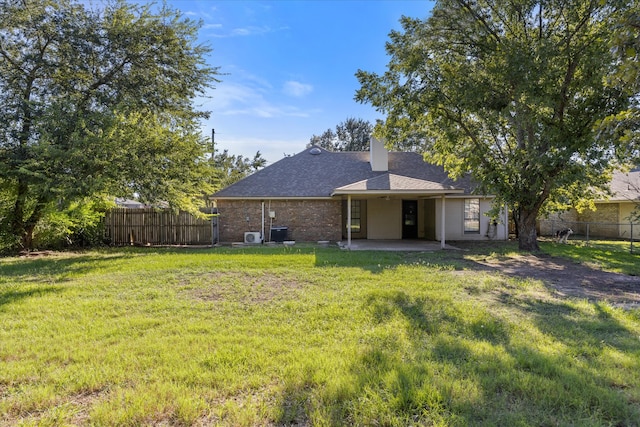 rear view of property featuring a patio area and a lawn