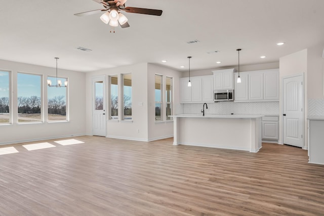 10 Louis Rd, Sherman, TX 75090 - unfurnished living room with light wood-type flooring, visible vents, recessed lighting, and ceiling fan with notable chandelier