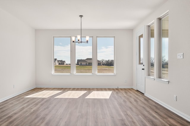 10 Louis Rd, Sherman, TX 75090 - unfurnished dining area featuring a notable chandelier, baseboards, and wood finished floors
