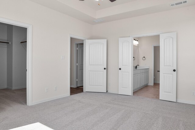 10 Louis Rd, Sherman, TX 75090 - unfurnished bedroom with light carpet, visible vents, baseboards, a spacious closet, and a raised ceiling