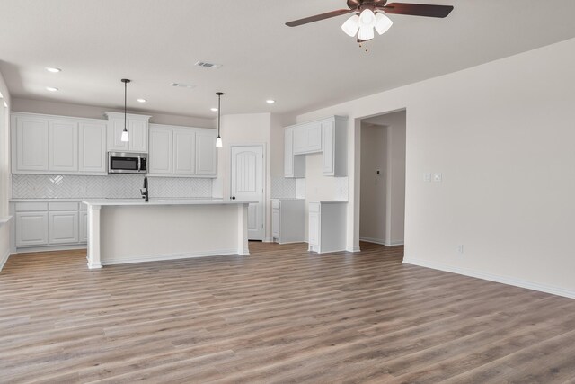 10 Louis Rd, Sherman, TX 75090 - kitchen with light wood finished floors, stainless steel microwave, visible vents, white cabinets, and ceiling fan