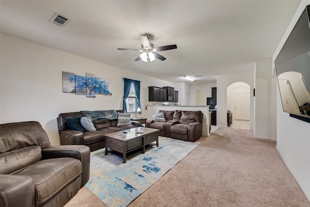 carpeted living room with ceiling fan