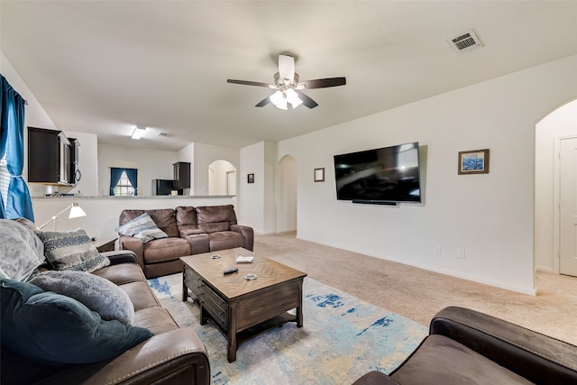 carpeted living room with ceiling fan