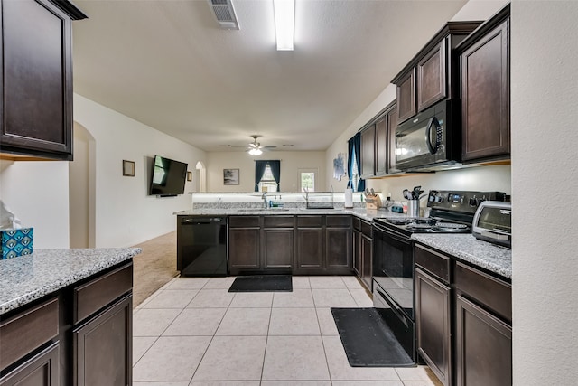 kitchen featuring dark brown cabinets, light tile patterned flooring, sink, black appliances, and ceiling fan