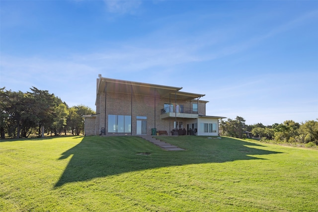 back of house with a lawn and a balcony