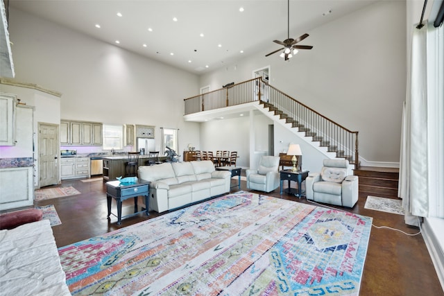 living room with a high ceiling and ceiling fan