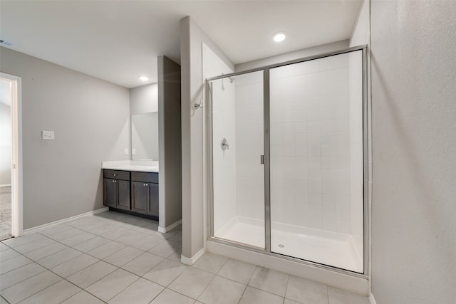 bathroom with walk in shower, vanity, and tile patterned flooring