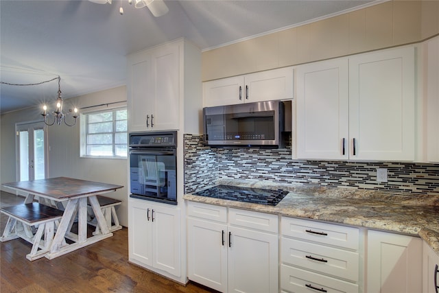 kitchen with dark wood-type flooring, white cabinets, ceiling fan with notable chandelier, black appliances, and crown molding