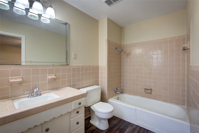 full bathroom featuring tiled shower / bath combo, vanity, toilet, and hardwood / wood-style flooring