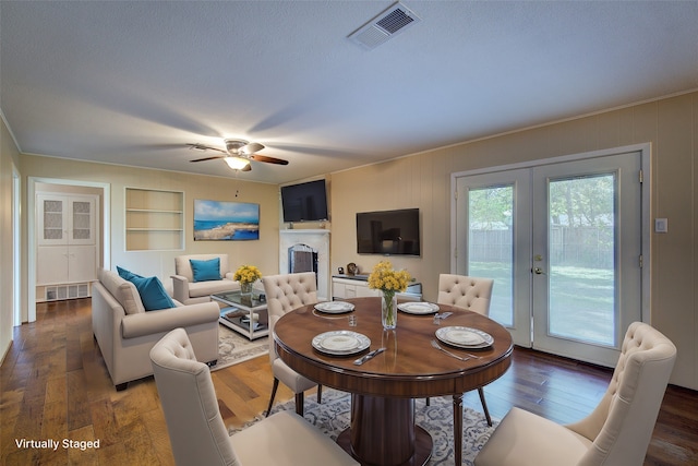 dining space with a textured ceiling, dark wood-type flooring, ceiling fan, french doors, and built in features