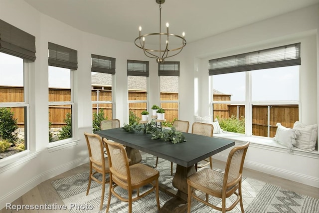 dining space featuring light hardwood / wood-style flooring and a chandelier