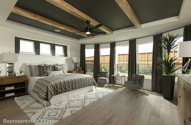 bedroom with beam ceiling, light hardwood / wood-style floors, and ceiling fan