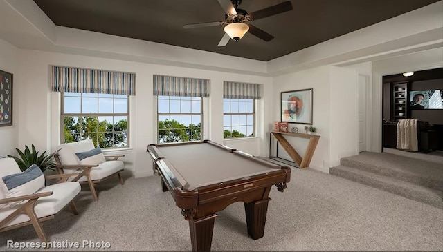 recreation room with a raised ceiling, pool table, ceiling fan, and light colored carpet