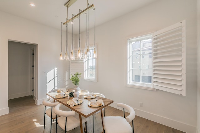 dining area with recessed lighting, wood finished floors, a wealth of natural light, and baseboards