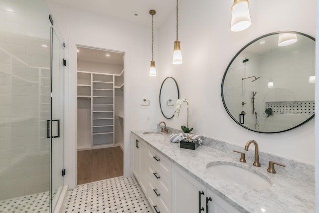 bathroom featuring double vanity, a shower stall, and a sink