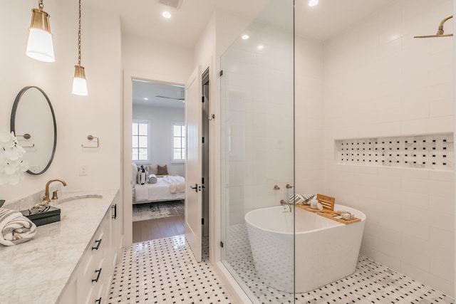 full bath with ensuite bathroom, tile patterned flooring, a freestanding bath, vanity, and recessed lighting