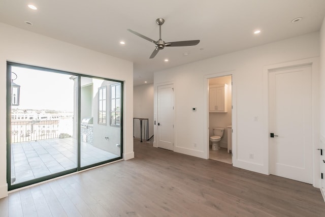 unfurnished bedroom featuring access to exterior, ensuite bath, wood finished floors, and recessed lighting