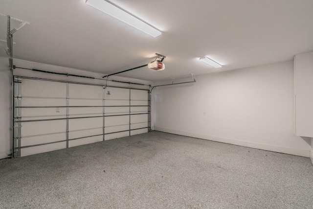 garage with baseboards and a garage door opener