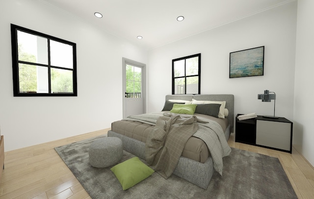 bedroom featuring light hardwood / wood-style flooring, crown molding, and multiple windows