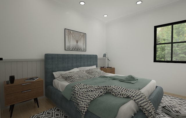 bedroom featuring light wood-type flooring and crown molding