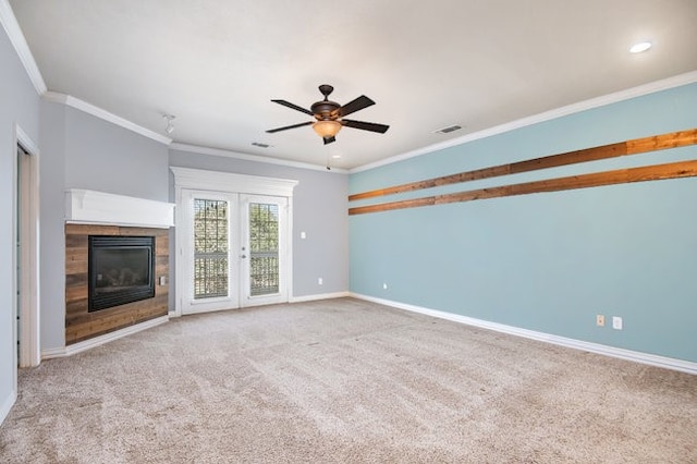 unfurnished living room featuring ceiling fan, light colored carpet, a fireplace, and crown molding