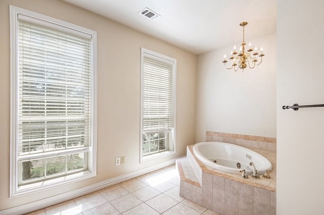 bathroom featuring a notable chandelier, tiled tub, and tile patterned floors