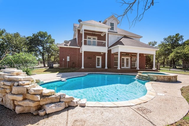 view of swimming pool featuring an in ground hot tub and a patio area