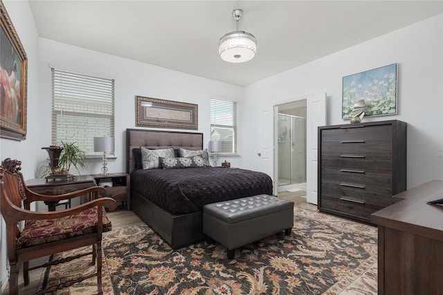 bedroom featuring light wood-type flooring and connected bathroom