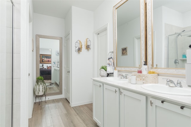 bathroom featuring wood-type flooring, vanity, and a shower with shower door