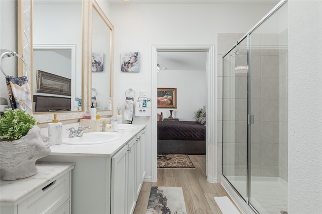 bathroom with walk in shower, vanity, and hardwood / wood-style flooring