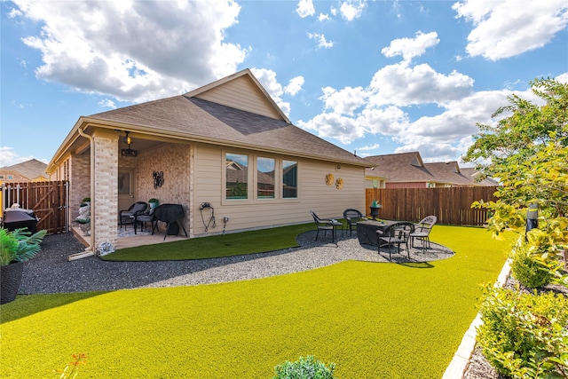 rear view of property featuring a lawn and a patio