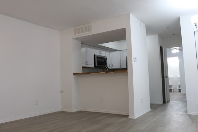 unfurnished living room with light wood-type flooring and ceiling fan