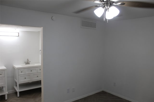 bedroom with ceiling fan, dark parquet flooring, and sink