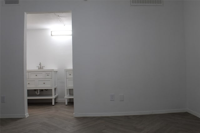 spare room with dark parquet flooring and sink