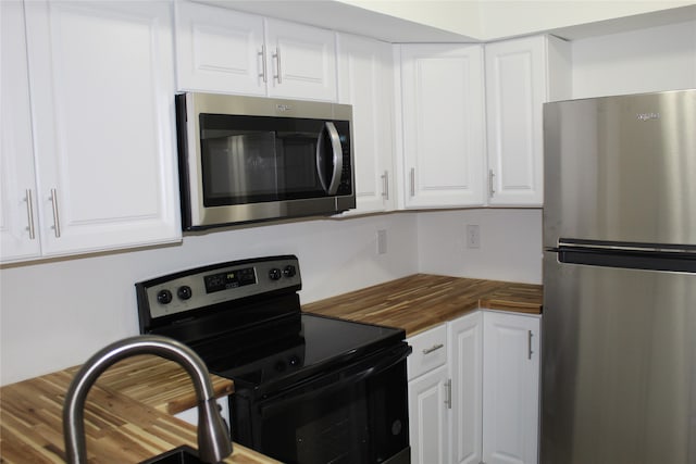 kitchen featuring butcher block counters, wood-type flooring, white cabinetry, and appliances with stainless steel finishes