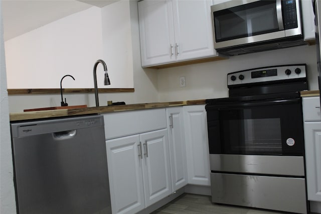 kitchen with white cabinetry, appliances with stainless steel finishes, and light hardwood / wood-style flooring