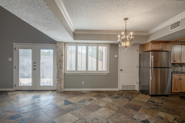 kitchen with hanging light fixtures, a chandelier, stainless steel refrigerator, crown molding, and decorative backsplash