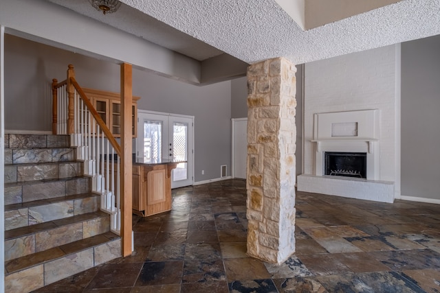 entrance foyer featuring a towering ceiling and a textured ceiling