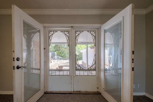 doorway with a textured ceiling, carpet flooring, and ornamental molding