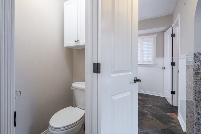 bathroom with a textured ceiling and toilet