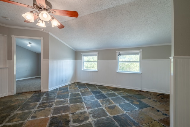 empty room with ornamental molding, lofted ceiling, ceiling fan, and a textured ceiling