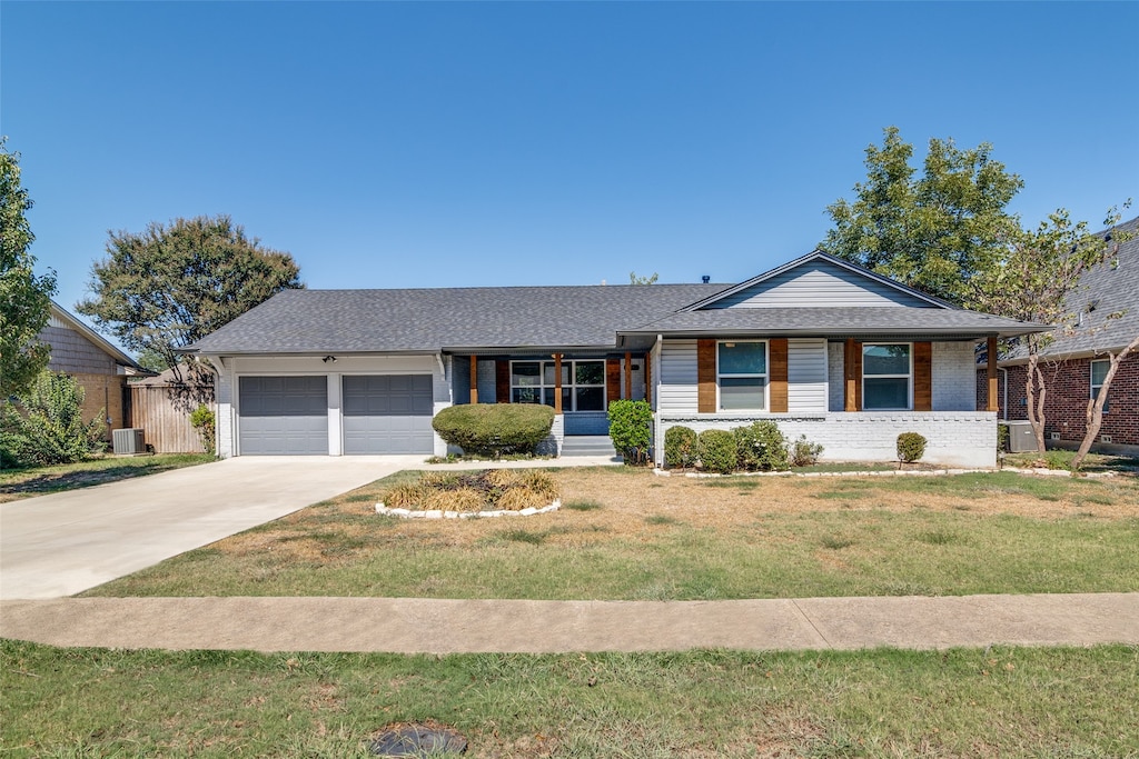 ranch-style home with central AC unit, a front yard, and a garage