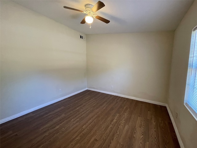 empty room featuring dark wood-type flooring and ceiling fan