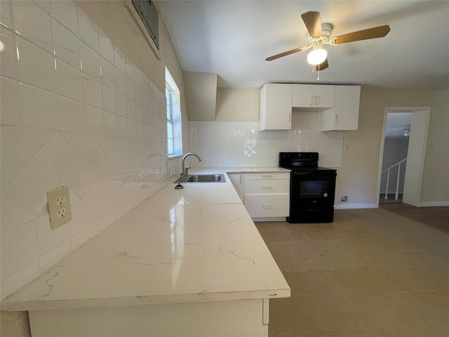 kitchen featuring white cabinets, tasteful backsplash, ceiling fan, black / electric stove, and sink