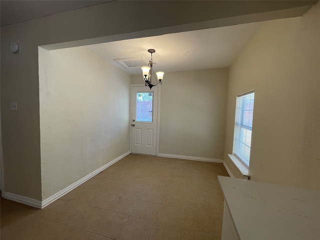 unfurnished dining area with tile patterned floors, a chandelier, and plenty of natural light