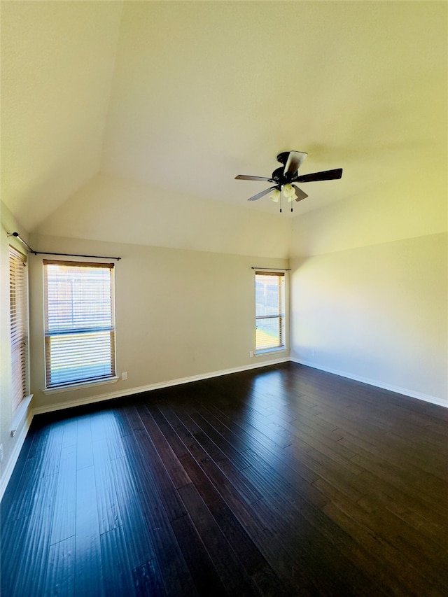 unfurnished room with ceiling fan, vaulted ceiling, dark hardwood / wood-style flooring, and a healthy amount of sunlight