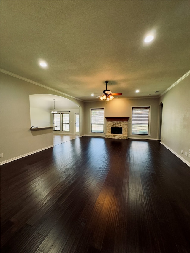 unfurnished living room with ceiling fan, a textured ceiling, crown molding, and dark hardwood / wood-style flooring