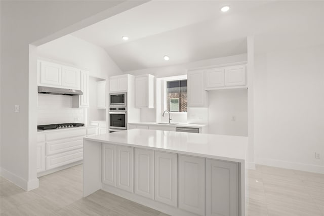 kitchen featuring sink, stainless steel appliances, white cabinets, and a kitchen island