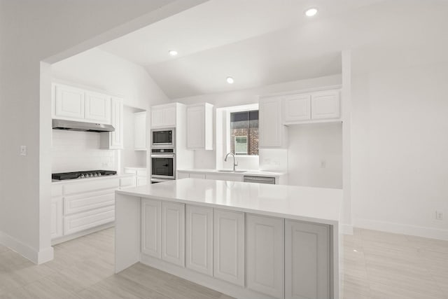 kitchen with sink, appliances with stainless steel finishes, white cabinets, and a kitchen island